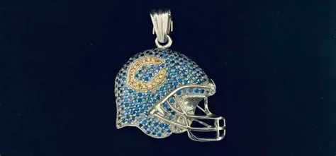 Football helmet pendant covered in blue and gold stones